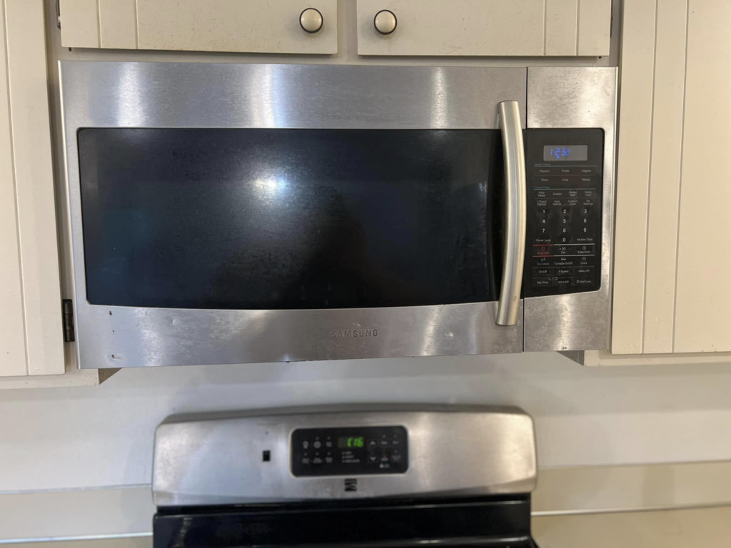 A smudged stainless steel microwave exterior needing cleaning by V's Residential Cleaning Services in Tacoma, WA.
