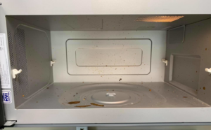A dirty microwave oven interior with food splatters and crumbs, ready for cleaning by Quality Cleaning in Summerville, SC.