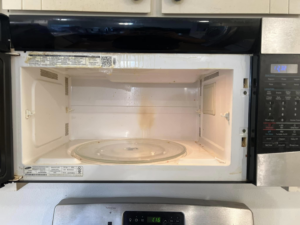 A dirty microwave interior before cleaning by V's Residential Cleaning Services in Tacoma, WA.
