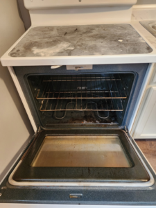 A dirty oven and stovetop before cleaning, demonstrating the need for services from Christina's Tidy Homes in Canton, OH.