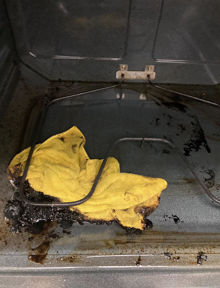 A very dirty oven interior with a cleaning cloth, showing the 'before' state of a house cleaning job by Cleanaround22 in Daly City, CA.