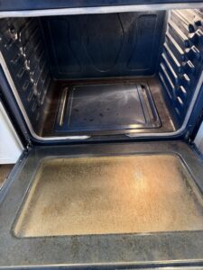A dirty oven interior with baked-on grime, illustrating a 'before' cleaning challenge for Messy To Clean in Aurora, IL.