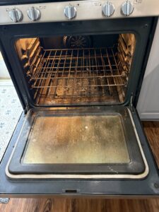 A dirty oven interior with grease and food residue, showing the 'before' state for Wilkie Wonders Cleaning in Akron, OH.