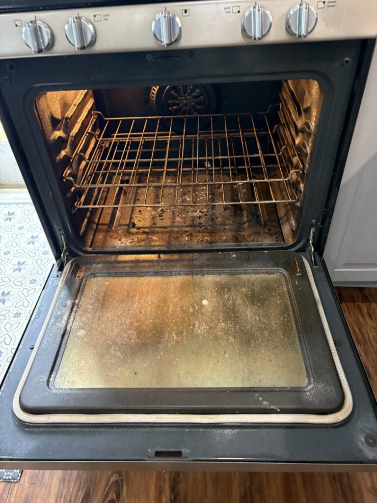 A dirty oven interior with grease and food residue, showing the 'before' state for Wilkie Wonders Cleaning in Akron, OH.