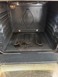 A dirty oven interior being cleaned by New Clean Service in Wilmington, NC, showing the effectiveness of their house cleaning.