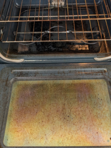 A heavily soiled oven interior with baked-on grease and food residue, illustrating a 'before' cleaning state by White Rose Cleaning in Idaho Falls, ID.