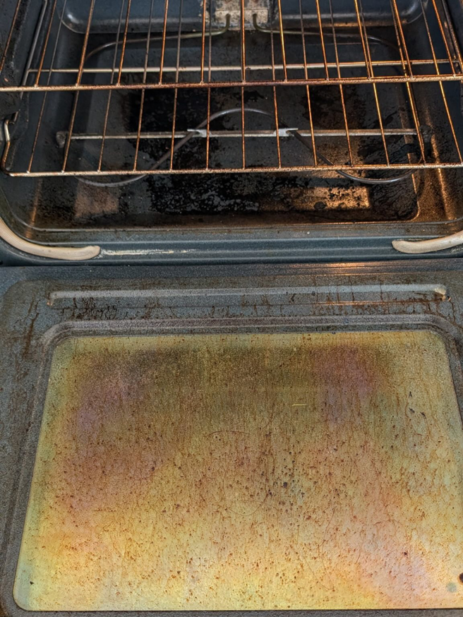 A heavily soiled oven interior with baked-on grease and food residue, illustrating a 'before' cleaning state by White Rose Cleaning in Idaho Falls, ID.