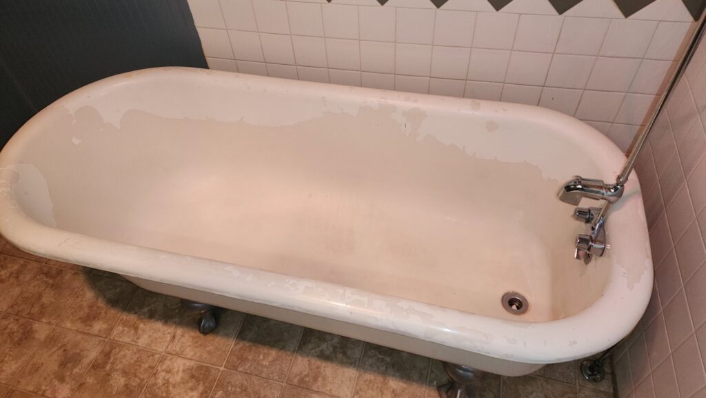 A dirty and peeling bathtub, illustrating a 'before' scenario for deep cleaning services by Eyedeal Cleaning Services in Gresham, OR.