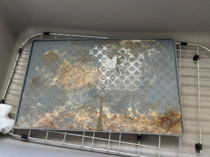 A dirty pet feeding mat covered in grime and residue, before cleaning by Spotless by Sam LLC in Green Bay, WI.