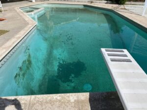 A dirty, cloudy residential swimming pool in need of cleaning services from Bright Side Pool Service LLC in Broken Arrow, OK.
