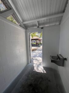 A dirty public restroom stall floor before cleaning by EB Restorations & Cleaning Services in Sparks, NV