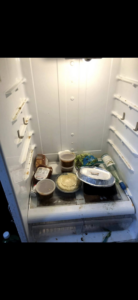 A dirty and cluttered refrigerator interior before professional cleaning by Elizabeth's cleaning in Cedar Park, TX.