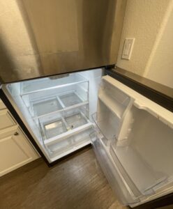 A dirty refrigerator with spills and crumbs, showing a 'before' state for Maid 2 Clean San Diego, CA