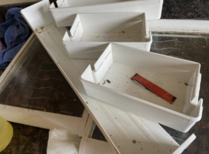 Dirty refrigerator drawers and a messy counter before cleaning by Crystal Clear Cleaning Services in New Haven, CT
