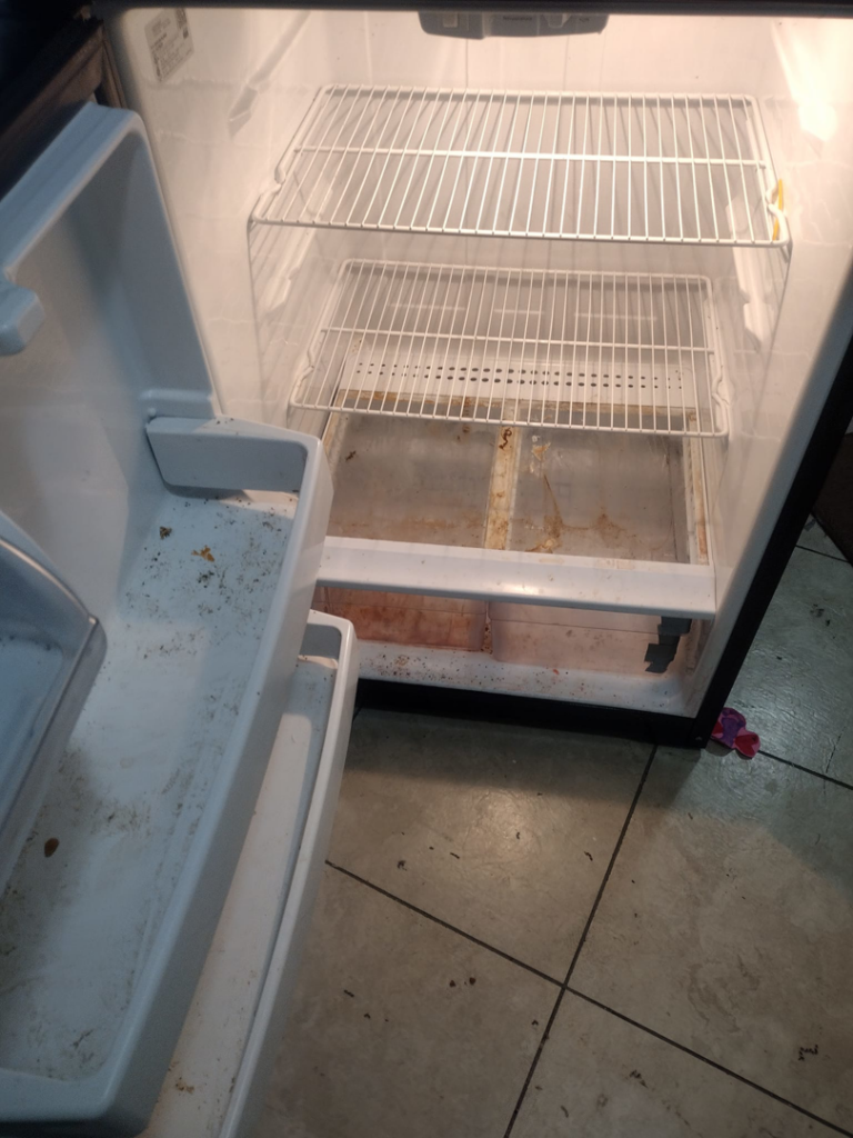 The dirty interior of a refrigerator before professional cleaning by By Grace Cleaning Solutions, LLC in Cincinnati, OH.