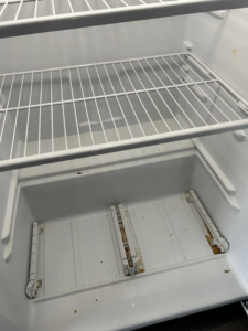 The dirty interior of a refrigerator before professional cleaning by E & S Cleaning Services L.L.C in Nampa, ID.