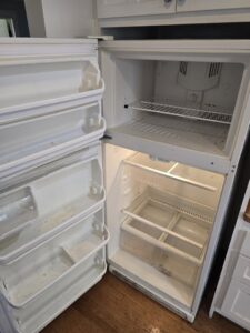 The dirty interior of a refrigerator, showing a 'before' state for cleaning services by Maid 2 Clean San Diego, CA