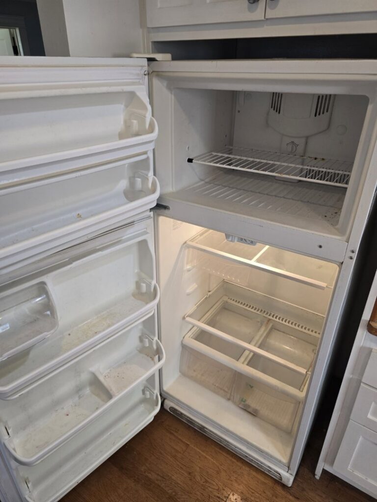 The dirty interior of a refrigerator, showing a 'before' state for cleaning services by Maid 2 Clean San Diego, CA