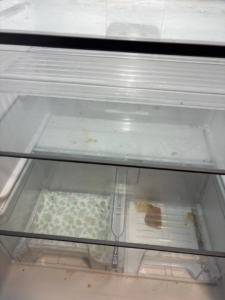 A messy refrigerator interior with dirty shelves and drawers, awaiting cleaning from Sprinkled Clean in Bangor, ME.