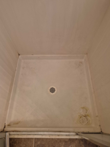 A dirty shower pan with visible grime and mold, indicating a before-cleaning state by Veter Clean in Gilbert, AZ.