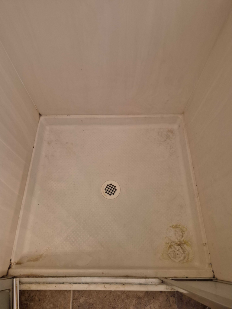 A dirty shower pan with visible grime and mold, indicating a before-cleaning state by Veter Clean in Gilbert, AZ.
