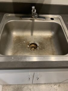 A dirty stainless steel sink, showing the need for cleaning by West & Co Cleaning Services in Laurel, MD