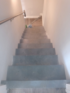 Dirty stairs with cleaning supplies at the bottom, ready for a house cleaner from Little Springs Cleaning in Chattanooga, TN.