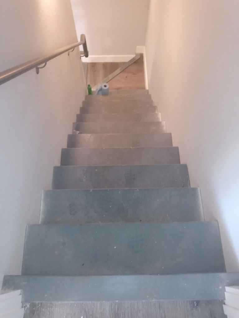 Dirty stairs with cleaning supplies at the bottom, ready for a house cleaner from Little Springs Cleaning in Chattanooga, TN.