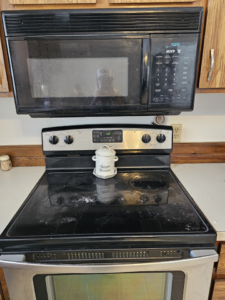 A dirty stove and microwave before professional cleaning by Nikki Sue's Cleaning Services in Gillette, WY.