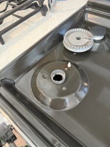 A dirty stove burner area with grease and grime, illustrating a 'before' cleaning challenge for Messy To Clean in Aurora, IL.