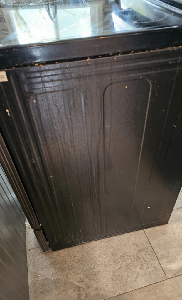 A dirty stove side with visible grime and streaks before cleaning by Five Stars Cleaning Services in Beaverton, OR.