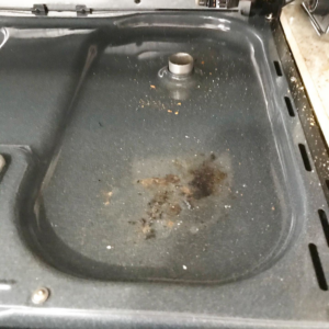A dirty stove top with grease and food residue before cleaning by Lourdes Home Cleaning in East Hampton, NY.