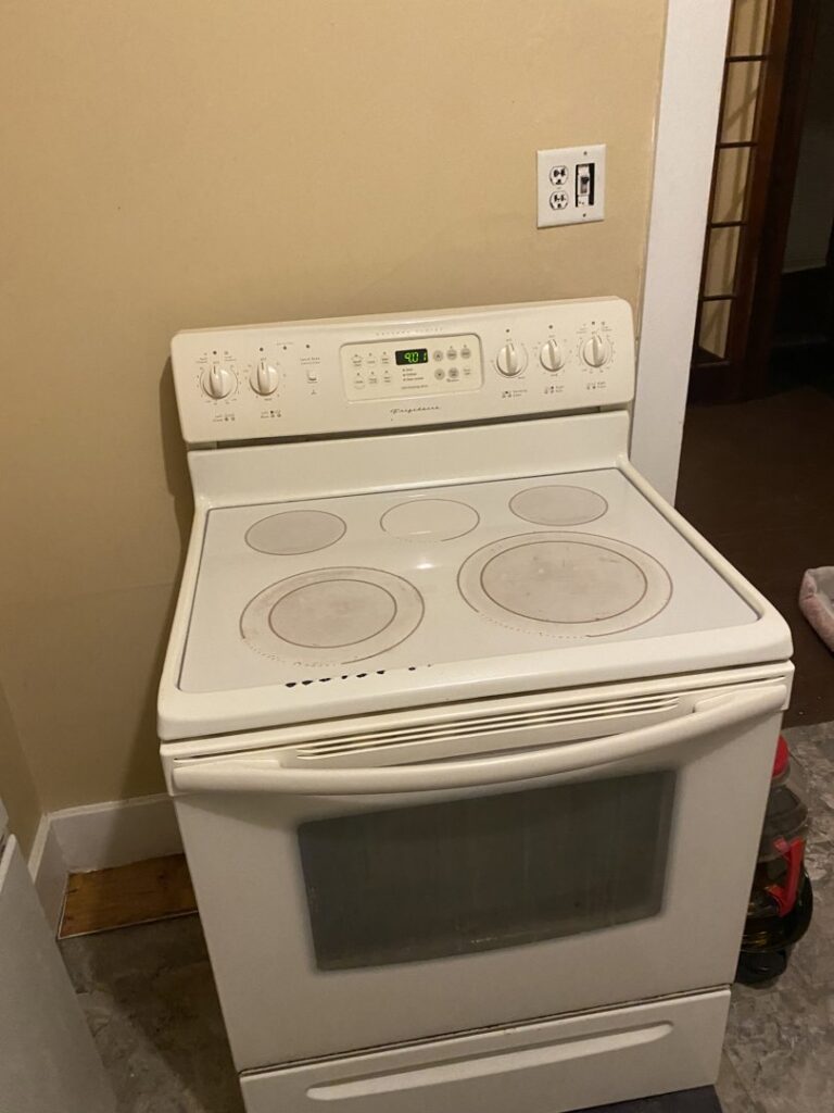 A dirty stove top with visible grime and food residue, indicating a cleaning task for Final Touch & More in Fort Wayne, IN