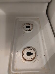 A very dirty stovetop with burnt-on food and grime, before cleaning by Chelle's Cleaning Services in Gary, IN.