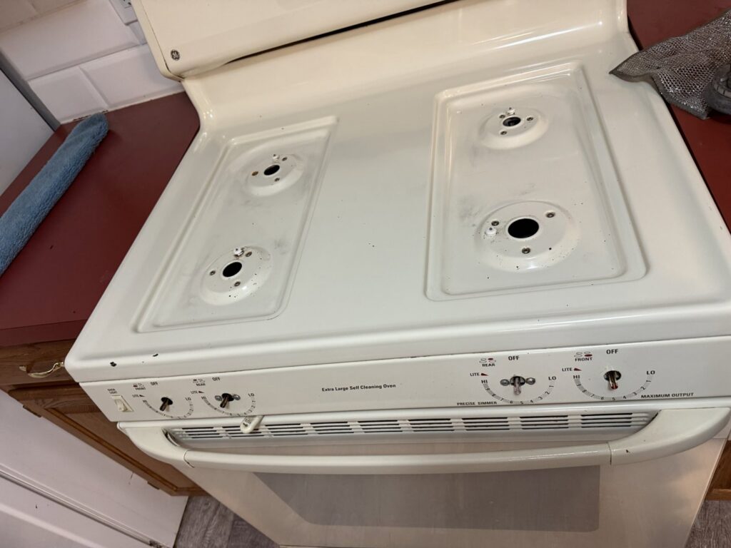 A dirty stovetop with food residue, demonstrating a typical 'before' cleaning scenario for Messy To Clean in Aurora, IL.