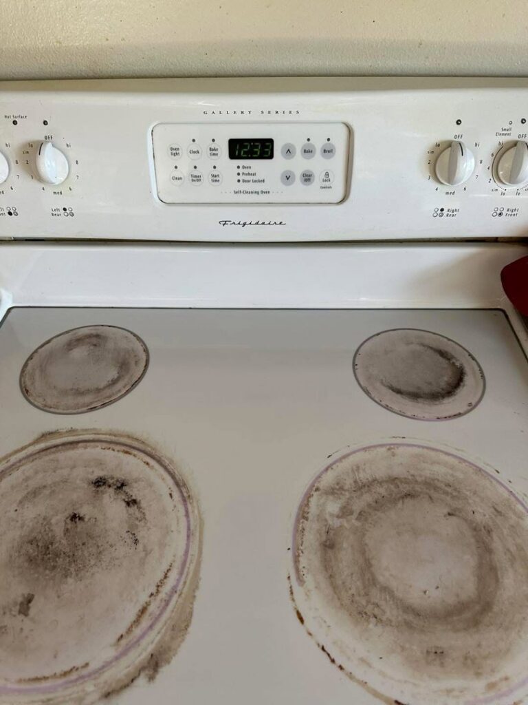 A dirty stovetop with burnt-on residue before cleaning by Teri Lynn's Cleaning in Williston, ND.