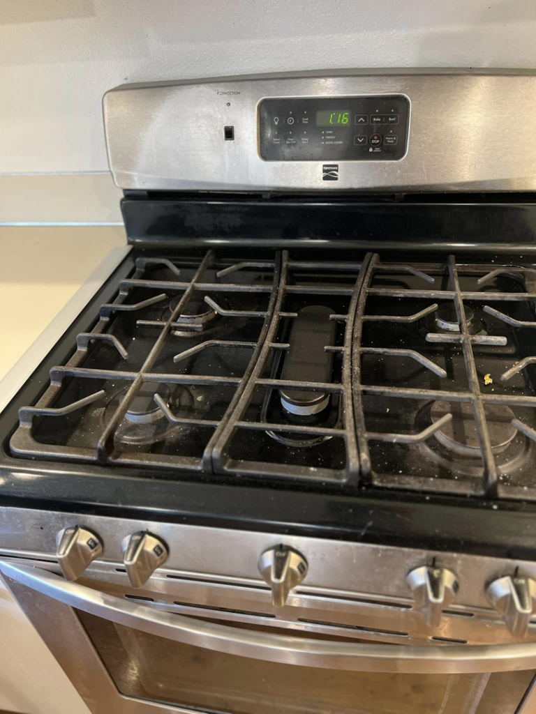 A dirty stovetop with food debris before cleaning by V's Residential Cleaning Services in Tacoma, WA.