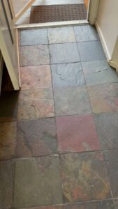 A dirty tiled floor at an entrance, showing a before-cleaning state for Bee-Dazzled Cleaning Service in Long Beach, CA.