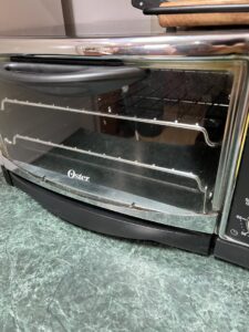 A dirty toaster oven in a kitchen, demonstrating the need for appliance cleaning services from Little Cubs Cleaning Services in Rochester, MN.