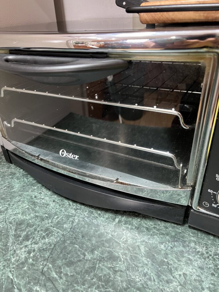 A dirty toaster oven in a kitchen, demonstrating the need for appliance cleaning services from Little Cubs Cleaning Services in Rochester, MN.