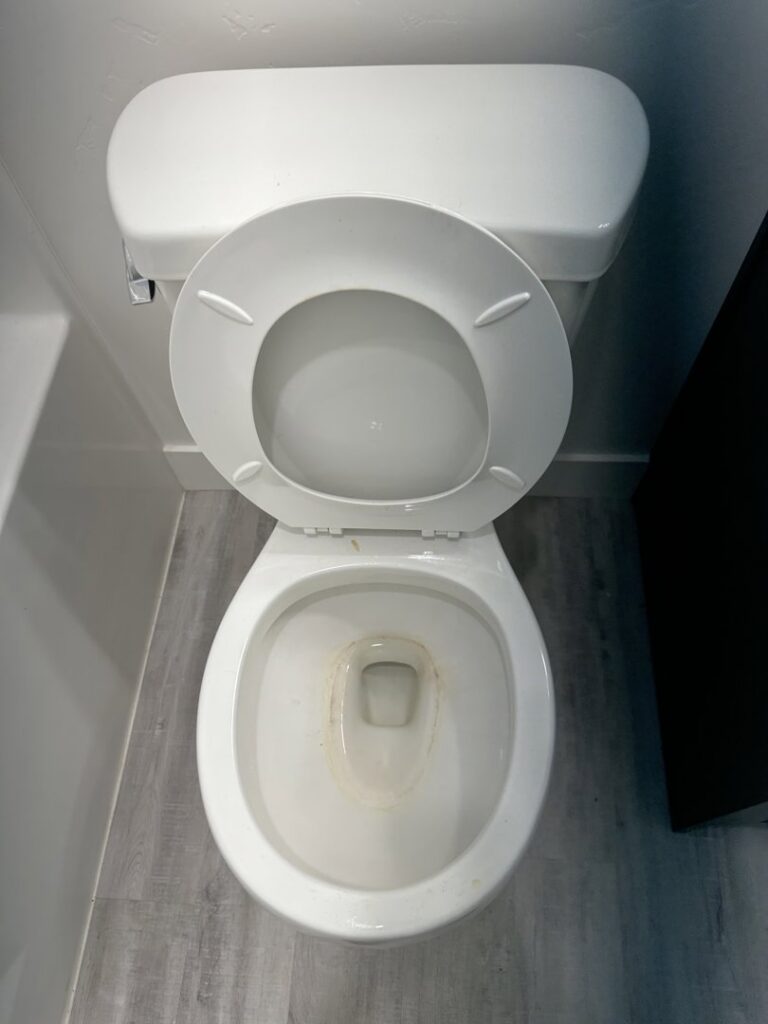 A dirty toilet with visible stains, showing a "before" state for bathroom cleaning services from Groove-By-Nature Cleaning in Idaho Falls, ID.