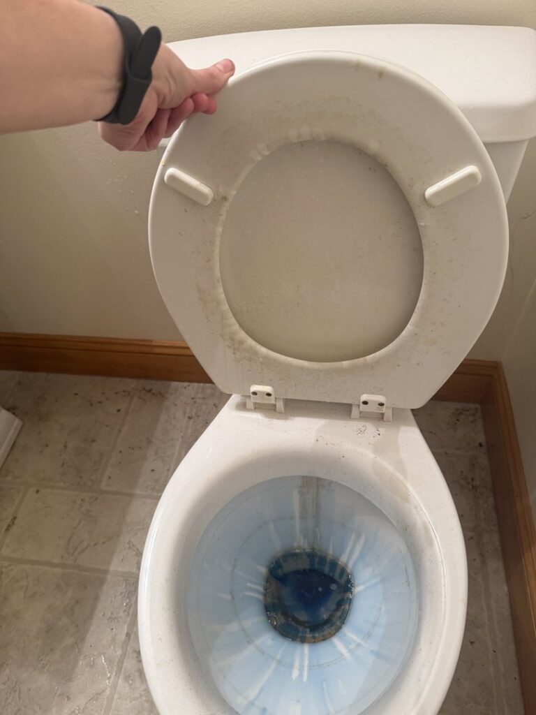 A dirty toilet showing grime and stains before a professional cleaning service by KDG Decluttering in Manchester, NH.