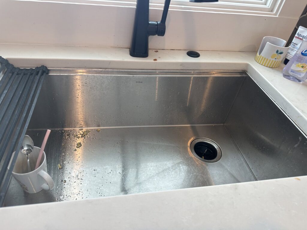 Close-up of dirty toilet seat hinges, showing grime before cleaning by J + M Cleaning, LLC in Flint, MI.