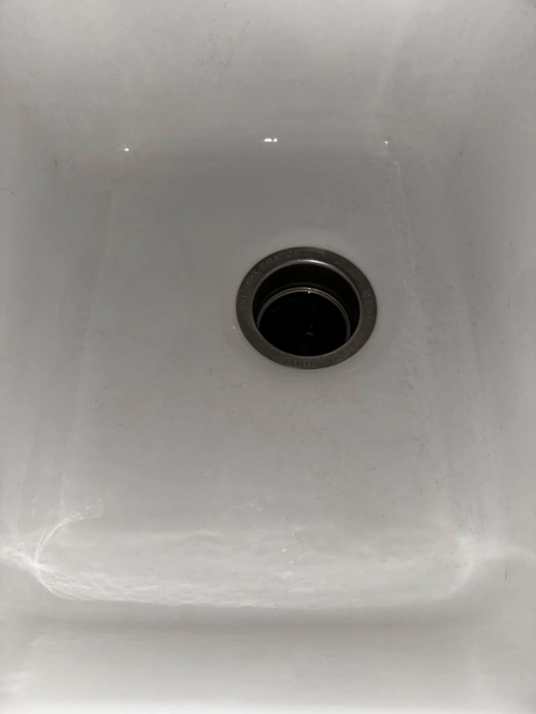 A dirty white kitchen sink showing grime before cleaning by Expert Cleaning On Demand in Tonganoxie, KS.