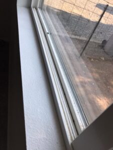 A close-up of a dirty window track and sill, indicating the need for professional cleaning by Blubyrd Cleaning Service in Boise, ID.