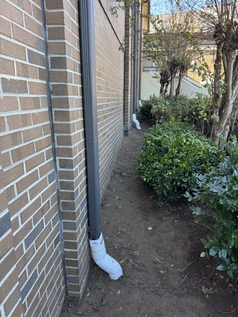 A downspout extension installed to direct rainwater away from a building foundation by Wetlock Waterproofing in Rock Hill, SC.
