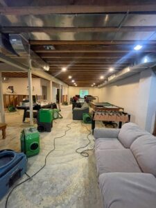 Drying equipment and exposed walls in a basement during water damage cleanup by NSH Home Services in Jersey City, NJ.