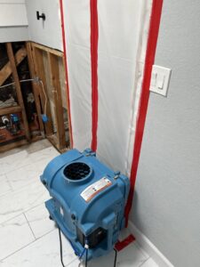 Drying equipment and a containment barrier set up in a water-damaged area by Emergency Flood Team in Gilbert, AZ