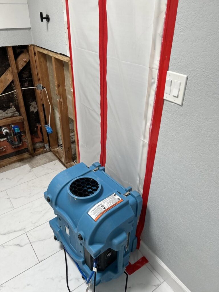 Drying equipment and a containment barrier set up in a water-damaged area by Emergency Flood Team in Gilbert, AZ