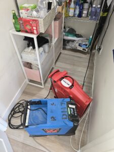 Drying equipment, including a dehumidifier and air mover, in a closet for water damage repair by Risk Free Serv San Diego, CA